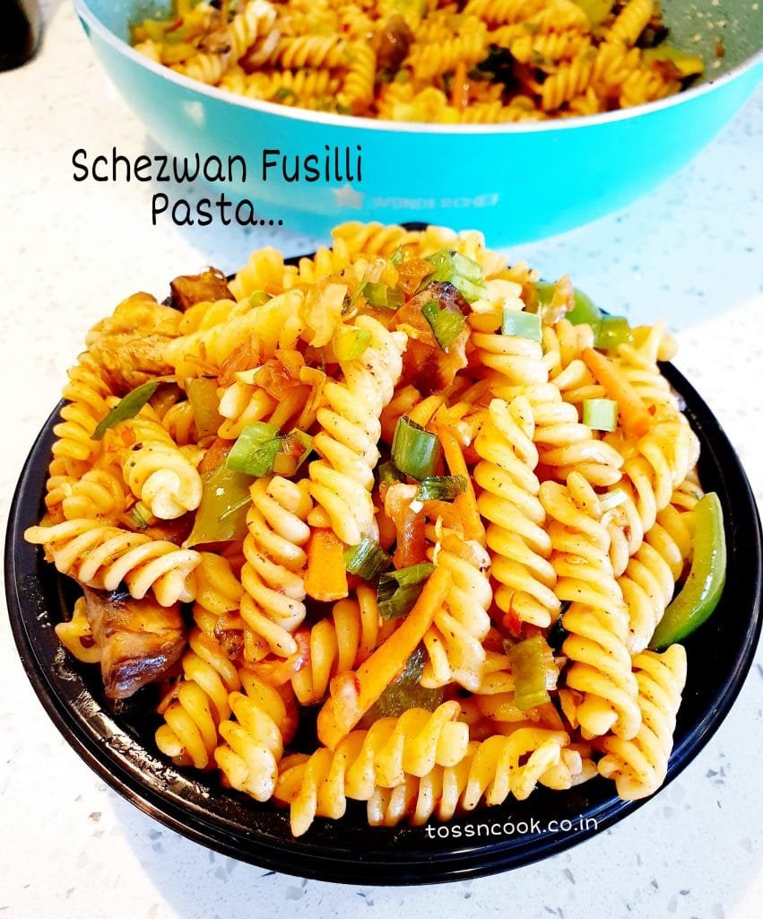 Schezwan Fusilli Pasta served in a Black plate