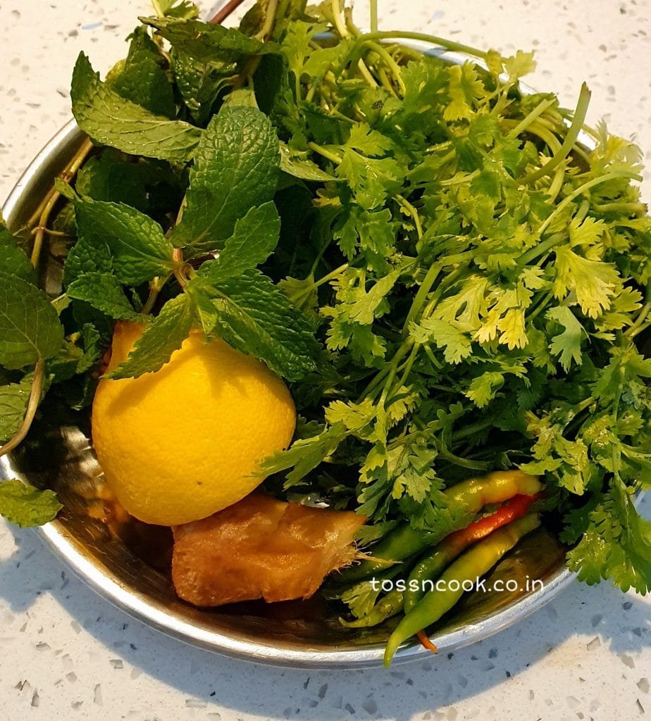 Green Coriander, sliced lemon, green chillies and mint leaves in a plate