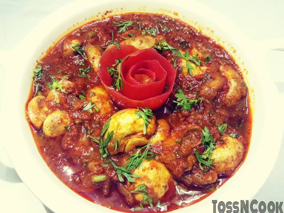 Kumbh Masala served in a plate decorated with flower tomato on top