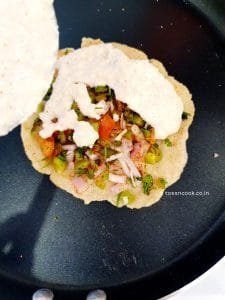 Adding another layer of batter on the uttapam and the veggies