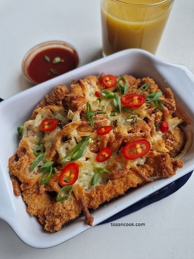 Air Fryer Cheesy Chicken Fingers recipe served in a oven tray along with sauce and juice in the side