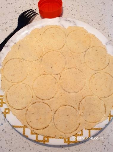 Round cut papdis on the kneaded dough using a cookie cutter