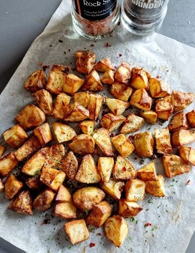 Air Fried Potatoes sprinkled with chives on a white butter paper